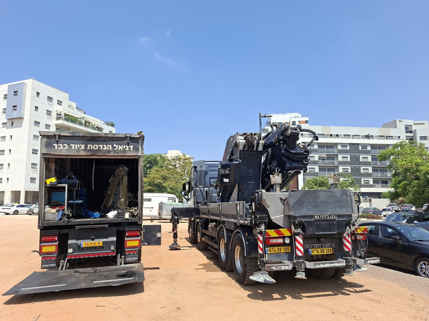 הניידת של דניאל פתוחה לצד מנוף FASSI כבד באזור עירוני
